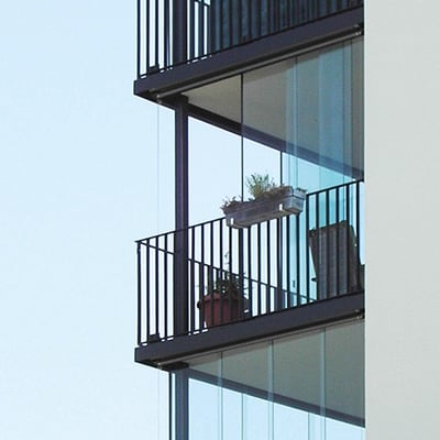 Ett ägenhetshus med inglasade balkonger som går att öppna